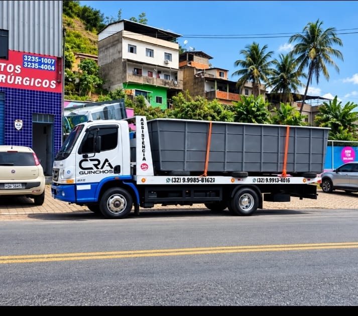 Caçamba metálica estacionária transportada pela C.R.A Guinchos em via urbana