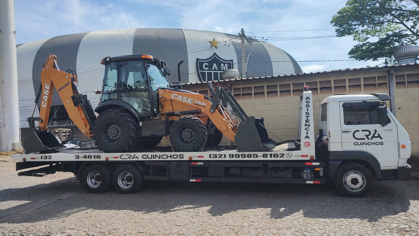 Retroescavadeira CASE 580N transportada na plataforma da C.R.A Guinchos